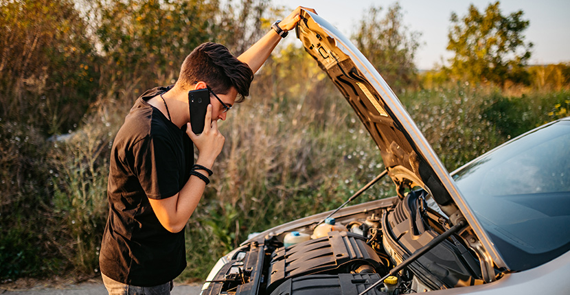 Guy on the phone looking under the hood