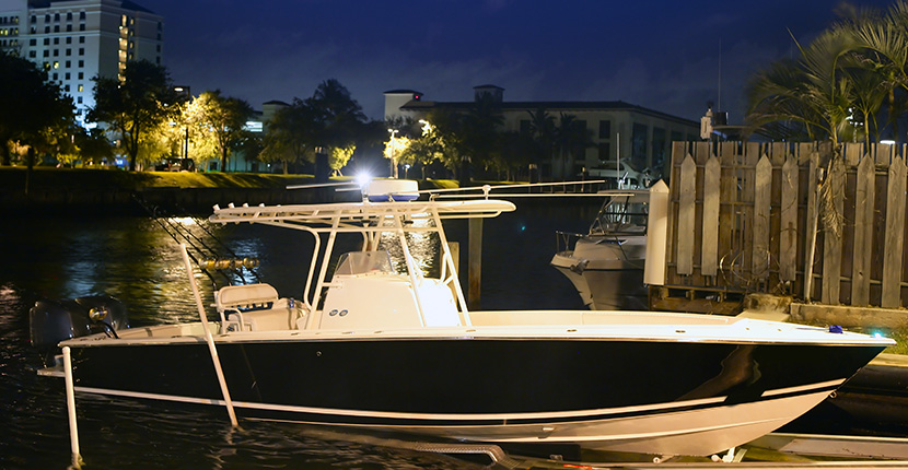 Black and white boat loaded on a trailer in the water at night