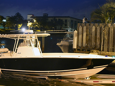 Black and white boat loaded on a trailer in the water at night