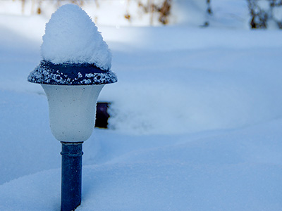 Solar powered light covered with snow