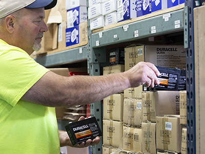 Employee selecting SLA batteries off a shelf