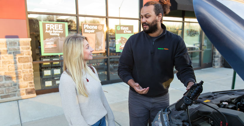 Employee talking to a customer about car batteries